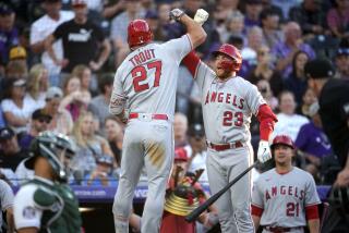 Los Angeles Angels' Mike Trout (27) celebrates after his solo home run with on-deck batter Brandon Drury.