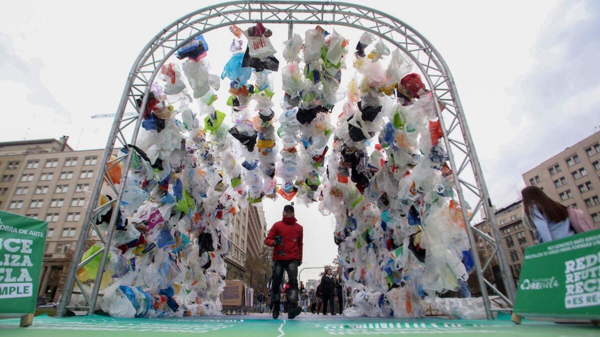 People walk through a tunnel made out of plastic bags in front of La Moneda presidential palace in Santiago, Chile. It was constructed for World Environment Day on Tuesday.