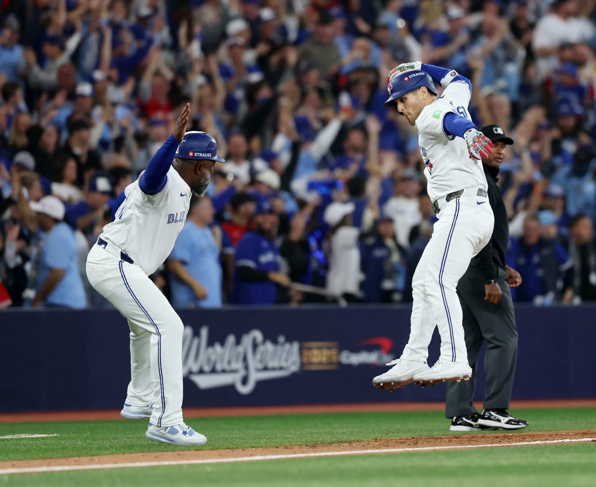 Toronto Blue Jays' Daulton Varsho celebrates this two-run home run with Toronto Blue Jays third base coach Carlos Febles.