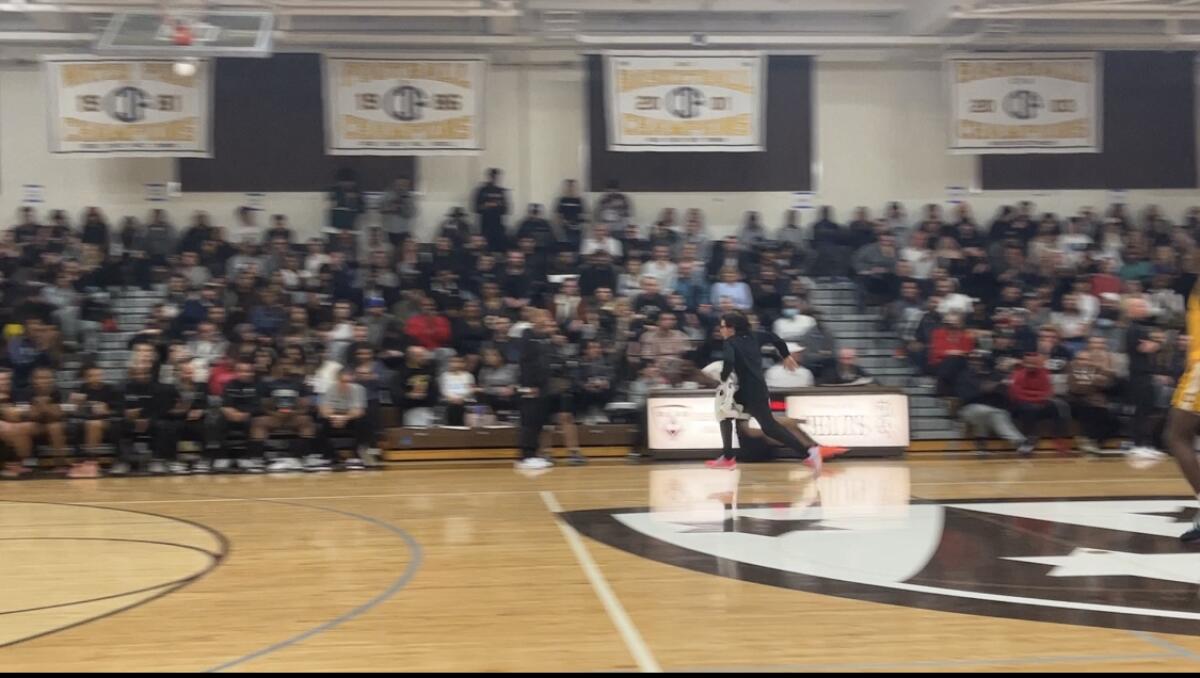 Sierra Canyon 12-year-old team manager Erik Ginsburg speeds off the court after mop-up duty.