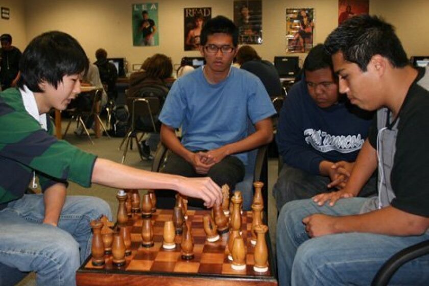Sowoong Park (left) and Francisco Sotelo play chess while Daryl Agustin and Pierson Cepeda watch. (Pat Sherman)