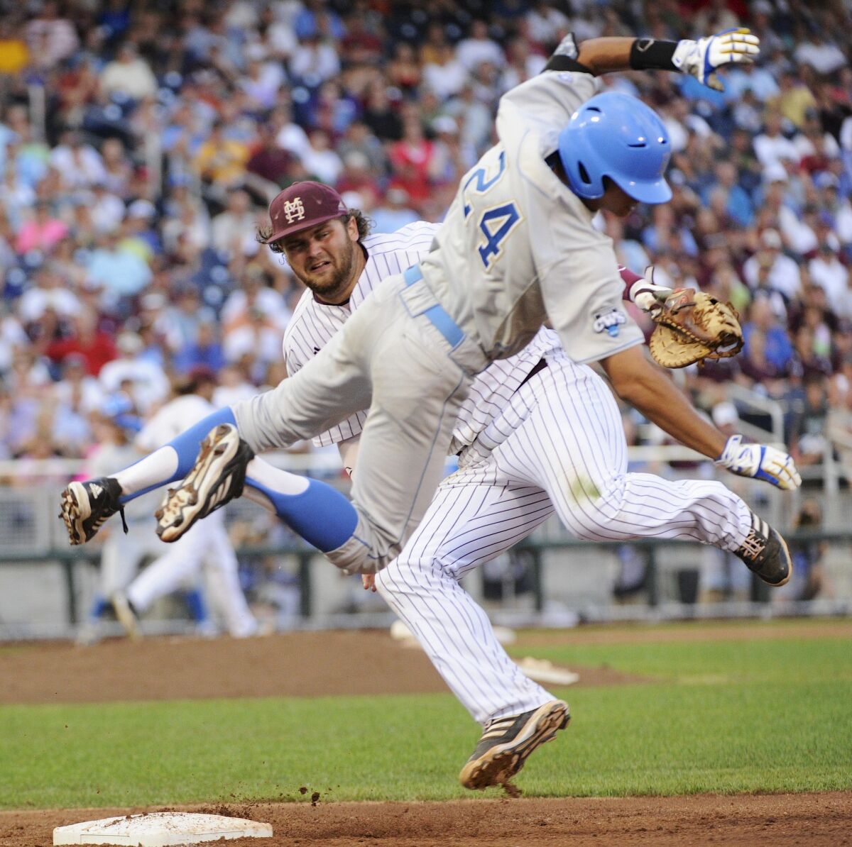 UCLA's Brian Carroll, right, and Mississippi State's Wes Rea collide a first base during the fourth inning of Game 1 of the College World Series on Monday.