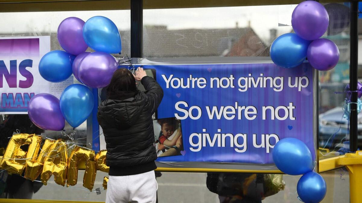 Supporters of Alfie Evans hang balloons at a bus stop opposite Alder Hey Children's Hospital in Liverpool.