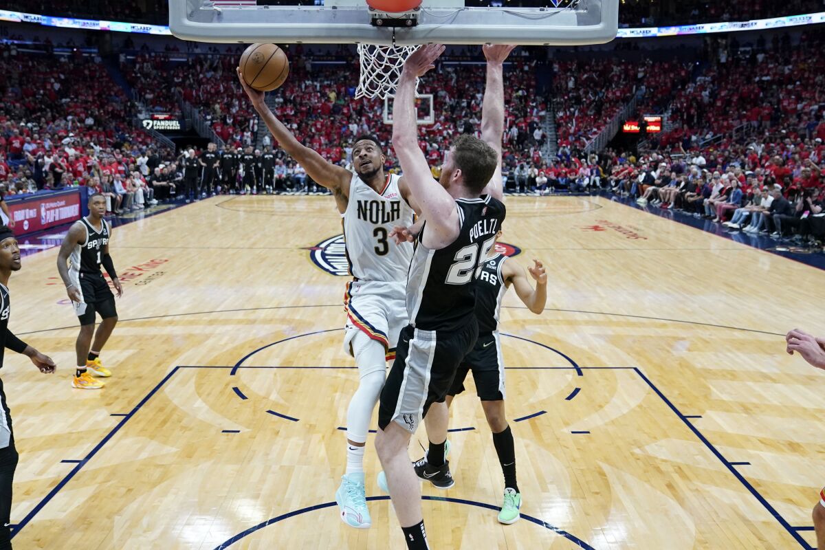 New Orleans Pelicans guard CJ McCollum goes to the basket against San Antonio Spurs center Jakob Poeltl.