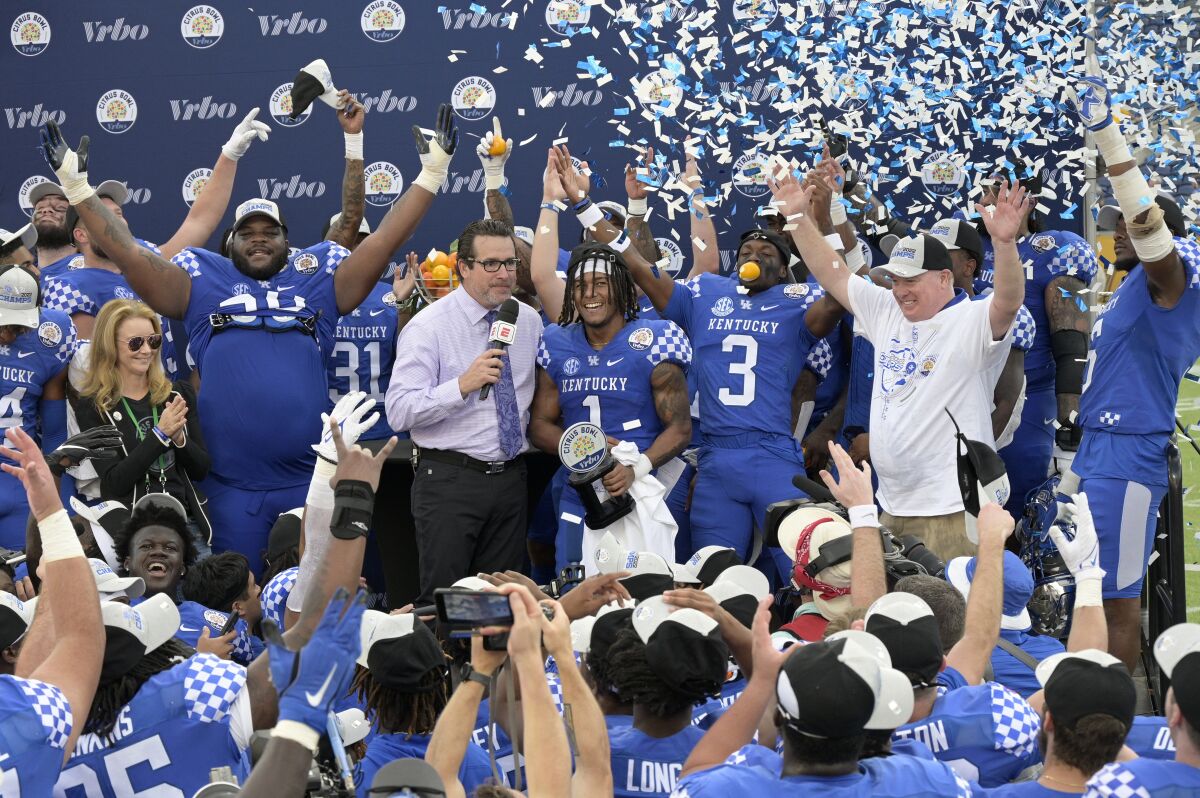 Kentucky wide receiver Wan'Dale Robinson (1) is presented the MVP trophy after their win over Iowa in the Citrus Bowl NCAA college football game, Saturday, Jan. 1, 2022, in Orlando, Fla. (AP Photo/Phelan M. Ebenhack)