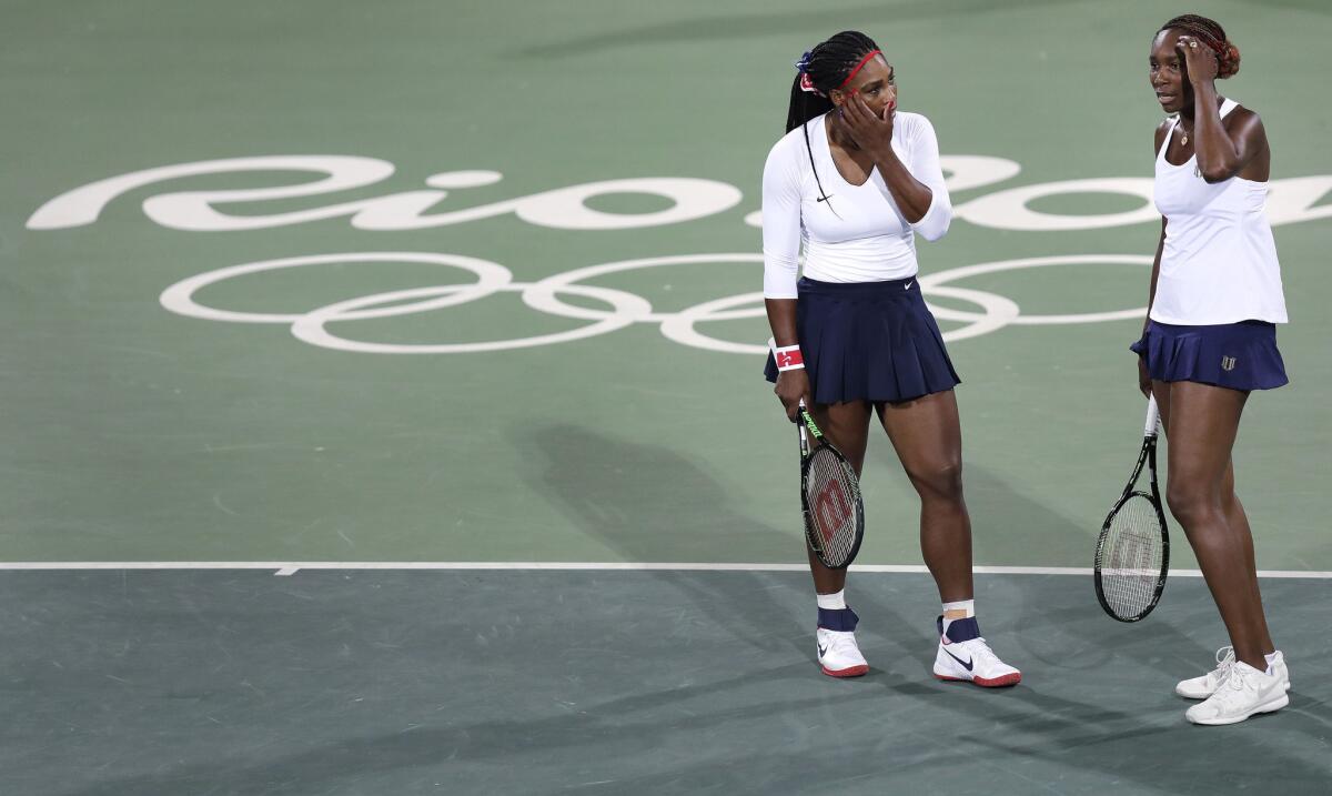 Venus Williams (d) dialoga con su hermana Serena después de perder un punto en el juego de dobles ante las checas Lucie Sarfarova y Barbora Strycova, en el tenis olímpico en Río 2016.