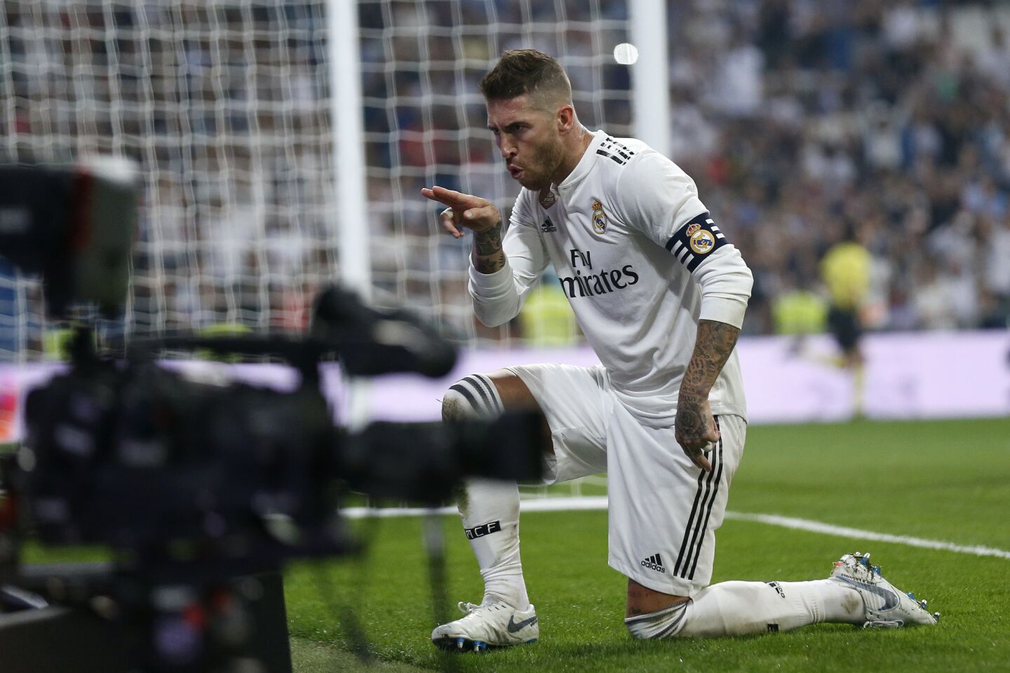 Real Madrid's Sergio Ramos celebrates in front of a TV camera after scoring a penalty and his team'ss fourth goal during the Spanish La Liga soccer match between Real Madrid and Leganes at the Santiago Bernabeu stadium in Madrid, Saturday, Sep. 1, 2018. (AP Photo/Andrea Comas)