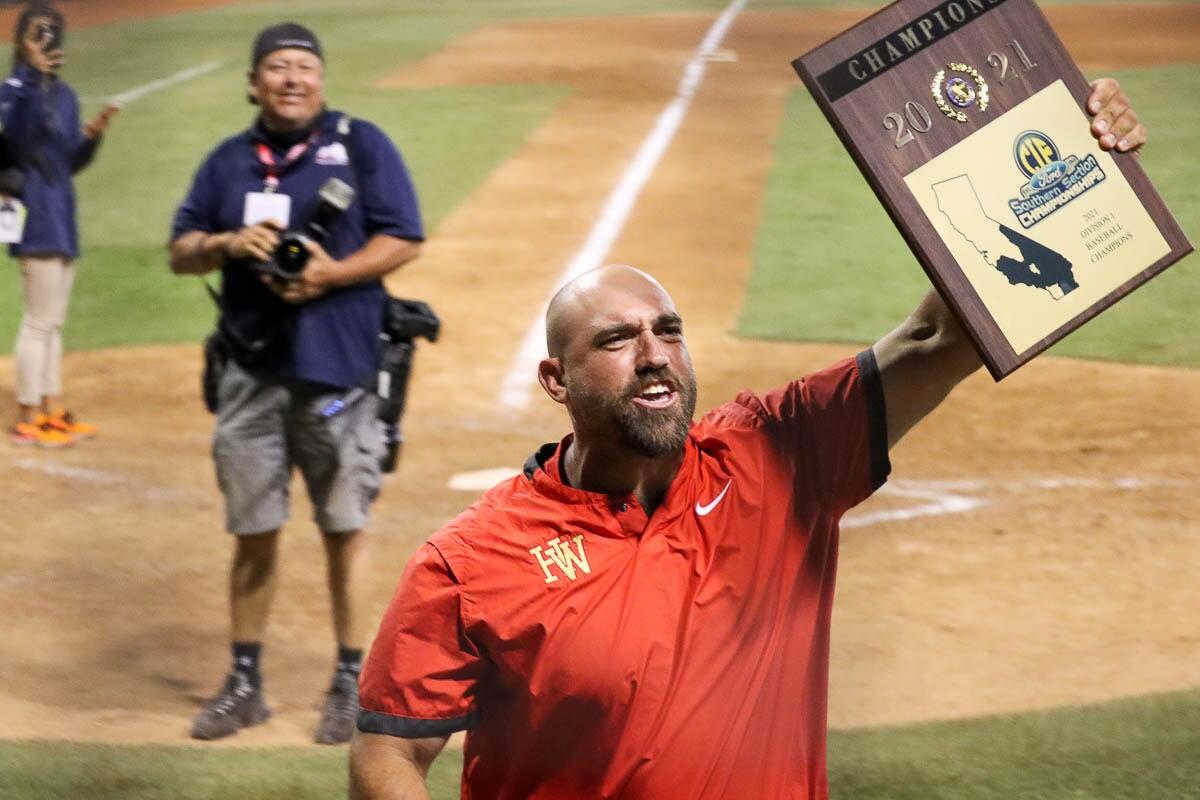 Harvard-Westlake baseball coach Jared Halpert celebrates while hoisting the Southern Section Division 1 championship plaque.