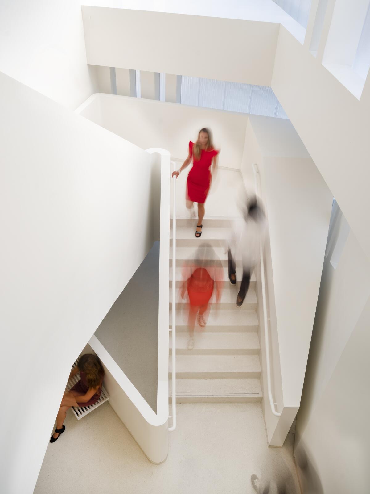 A winding staircase with people walking through the building. 