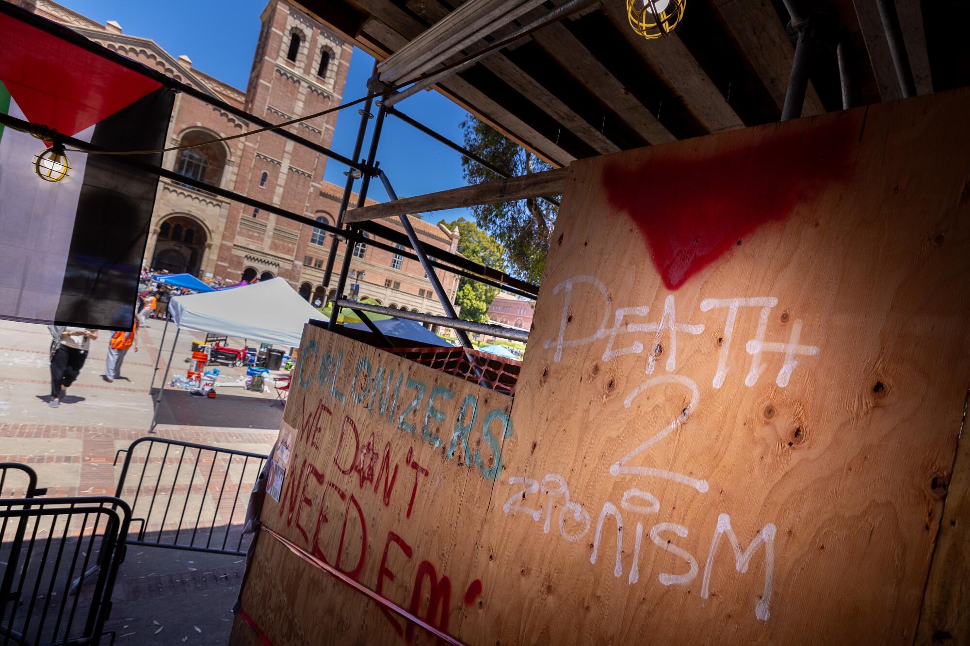 Wood panels near UCLA's Powell Library have graffiti with an inverted red triangle and the words "Death 2 Zionism"