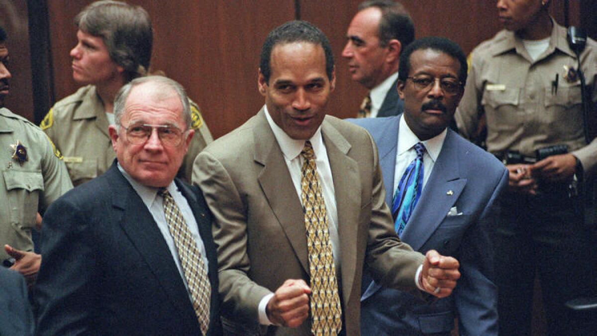 O.J. Simpson, al centro, reacciona al escuchar el veredicto de no culpable del asesinato de su esposa en octubre de 1995.