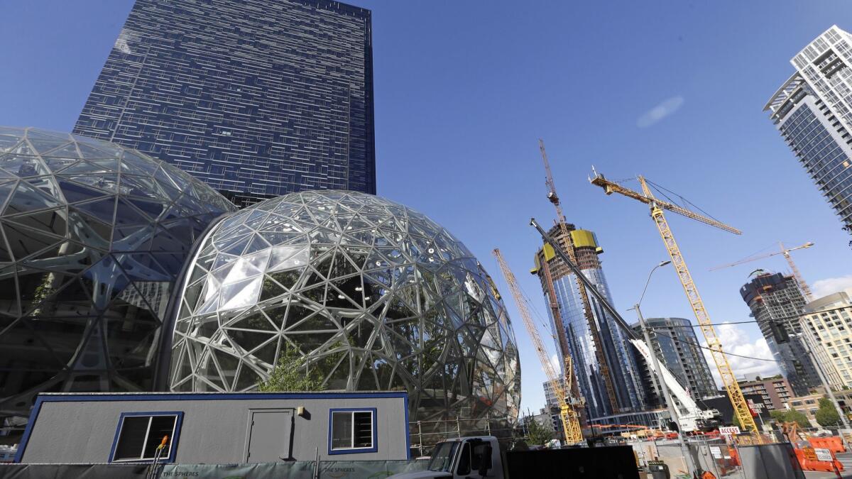 New construction at Amazon's complex in Seattle. The company said it is pausing construction on a new high-rise building while it awaits the outcome of a city proposal to tax worker hours to raise about $75 million a year for affordable housing and homelessness services.