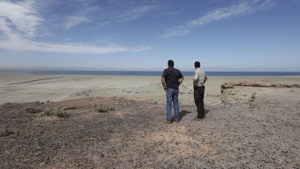 Matt Dessert, air pollution control officer of Imperial County, left, and Tom Anderson, veterinarian and naturalist, stand on Red Hill Bay, looking at a state-funded habitat restoration and dust suppression project at the Salton Sea.