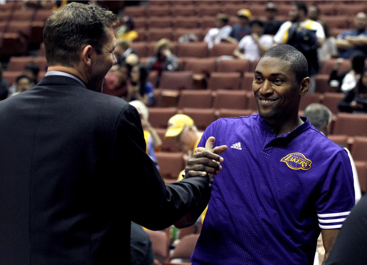 Lakers forward Metta World Peace greets Golden State Warriors interim Coach Luke Walton before a preseason game Thursday in Anaheim.