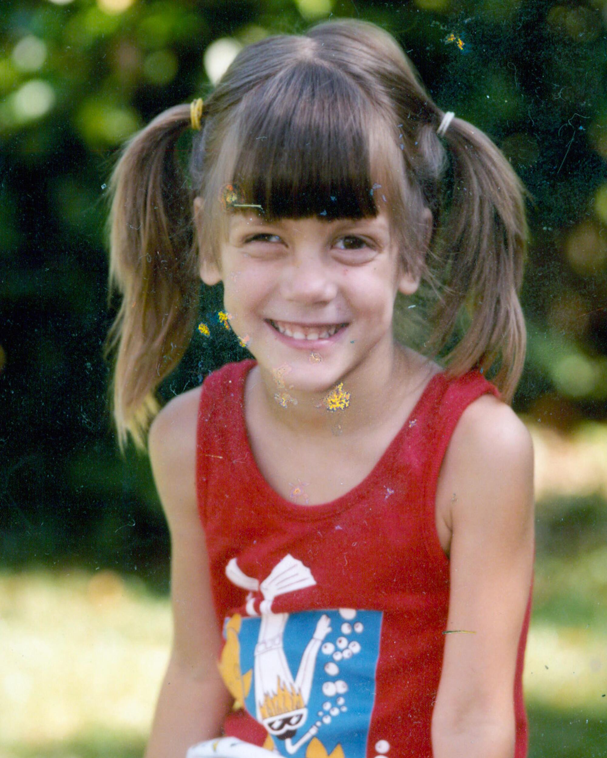 Harrison as a child with her hair in two ponytails.