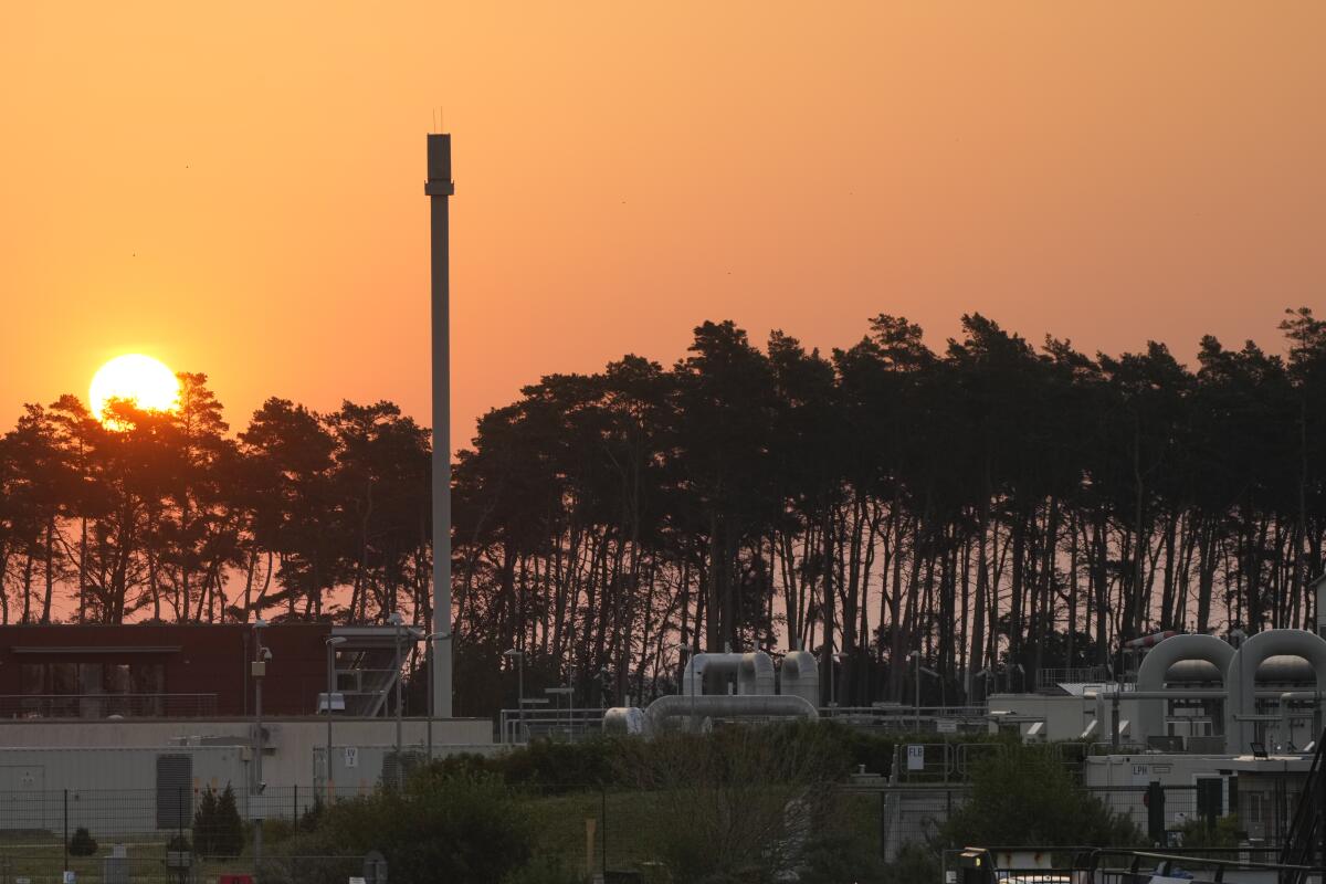 The sun rises behind the landfall facility of the Nord Stream 1 Baltic Sea pipeline and the transfer station of the OPAL gas pipeline, the Baltic Sea Pipeline Link, in Lubmin, Germany, Thursday, July 21, 2022. (AP Photo/Markus Schreiber)