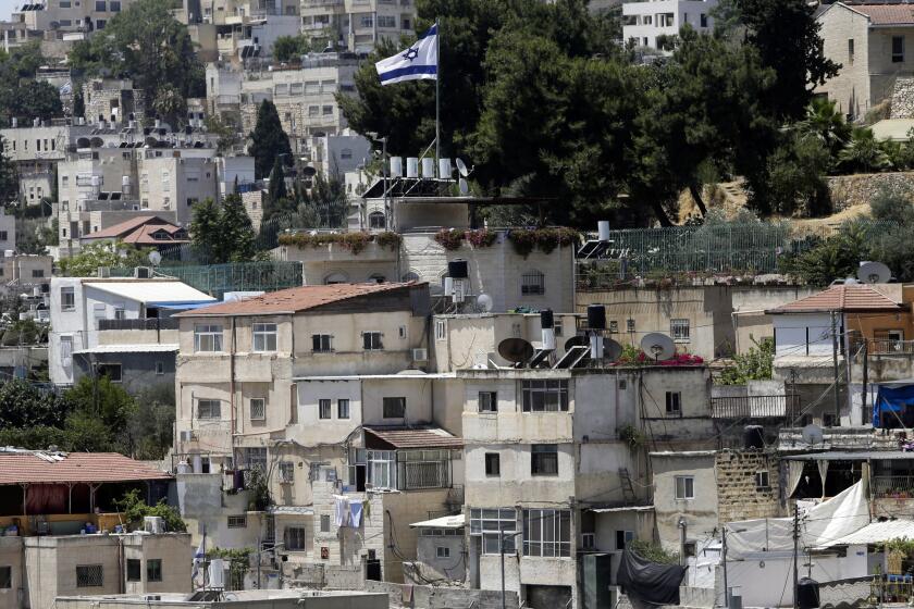An Israeli flag flies over a Jewish owned house in a Palestinian neighborhood of Silwan in east Jerusalem, Wednesday, July 1, 2020. Israeli leaders paint Jerusalem as a model of coexistence, the "unified, eternal" capital of the Jewish people, where minorities have equal rights. But Palestinian residents face widespread discrimination, most lack citizenship and many live in fear of being forced out. (AP Photo/Mahmoud Illean)