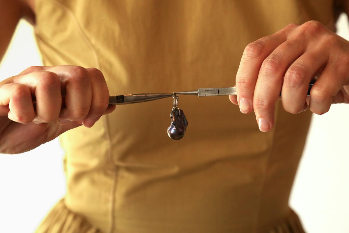 A person repairs a piece of jewelry.