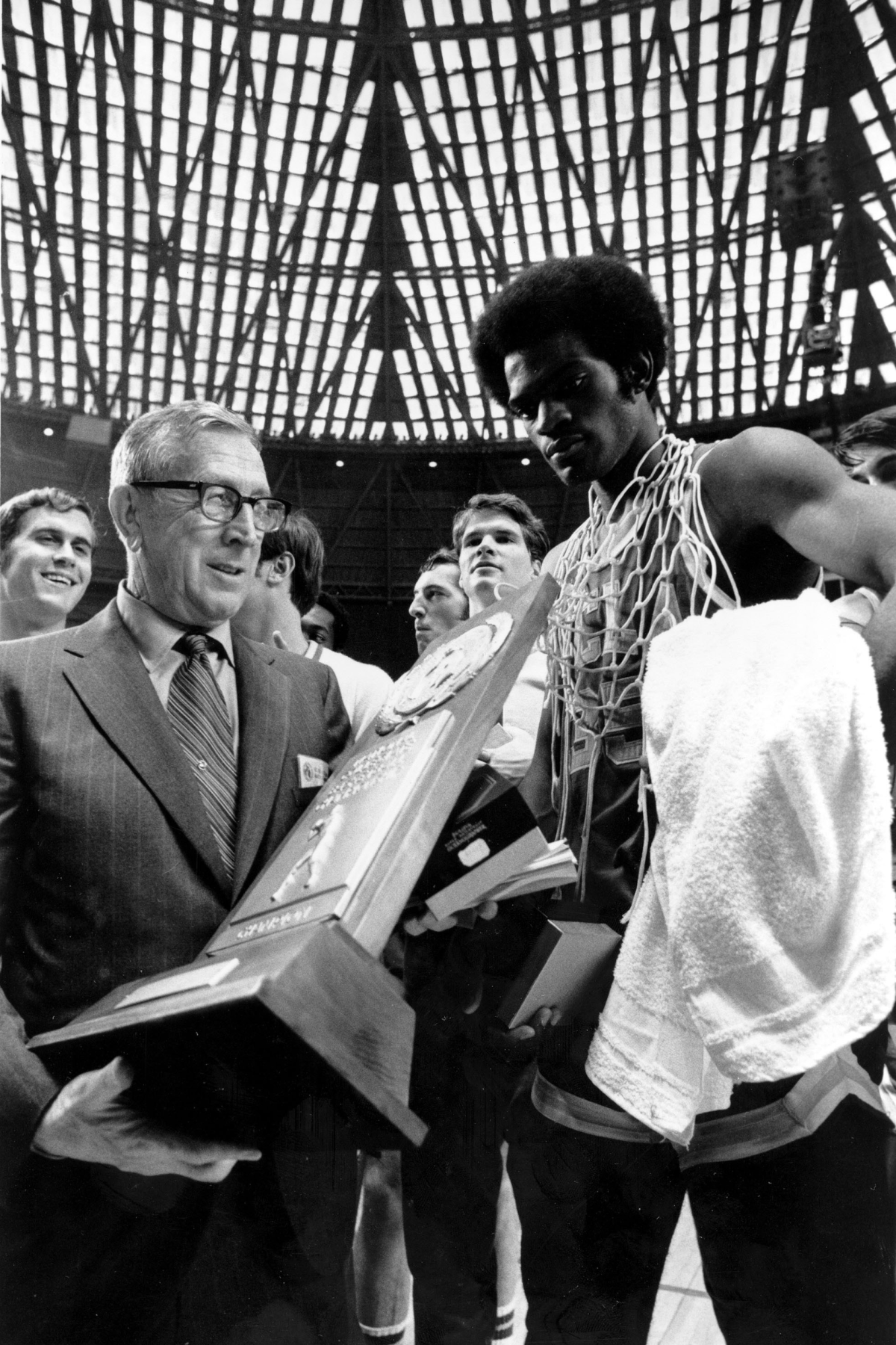 John Wooden holds the championship trophy and Sidney Wicks wears the net around his neck at the 1971 NCAA tournament.