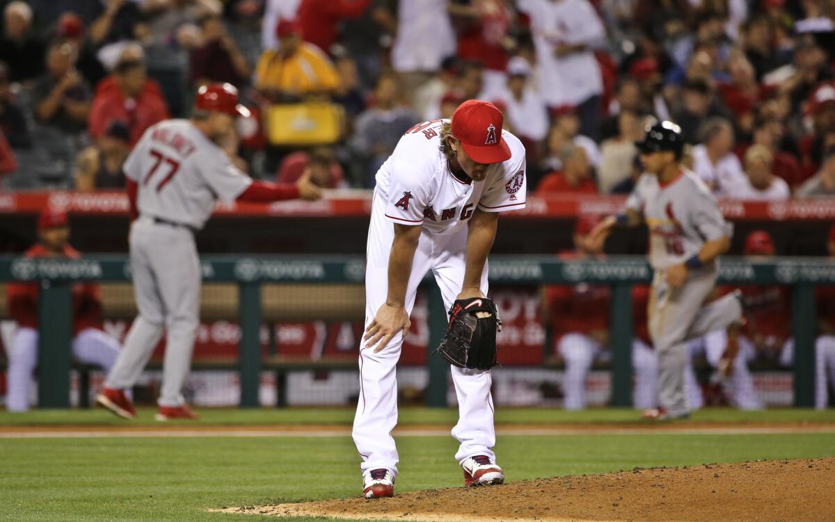 Angels starting pitcher Jered Weaver bends over on the mound as Cardinals infielder Matt Carpenter rounds the bases after hitting a three-run homer in a May 12 game in Anaheim.