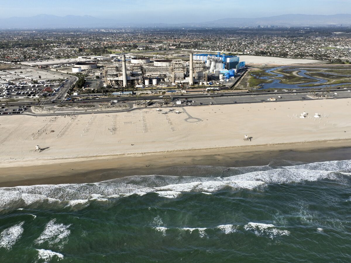 An aerial view of a power plant facility next to the beach