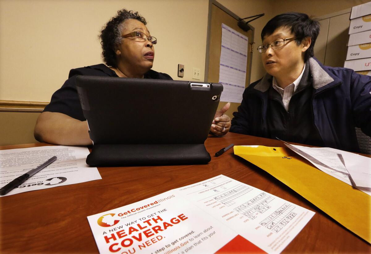 Navigator Mary Bennett, left, helps Min Lians shop for health insurance at the Family Guidance Center in Springfield, Ill.