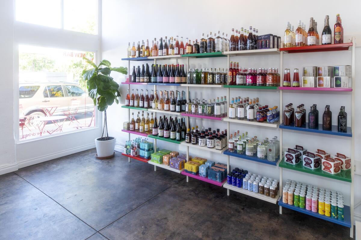 The interior of a store with white shelves stocked with colorful bottles and boxes.