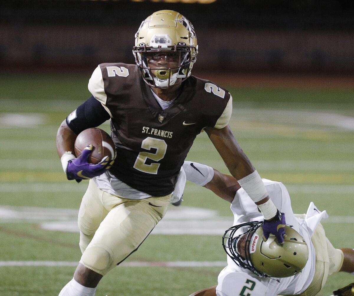 St. Francis' Max Garrison stiff arms and gets around for a long run against Mira Costa's Jackson Fischer in the season home opener non-league football game at St. Francis on Friedman Field on Friday, August 30, 2019.