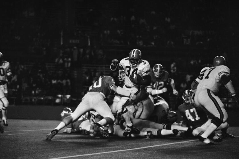 Fred Warren (34) carries for first down for Florida A&M in first quarter of Orange Blossom Classic with Jacksonville (Alabama) State in the Orange Bowl at Miami, Fla., Dec. 12, 1970. Making tackle is Gary Godfrey of Jacksonville. (AP Photo)