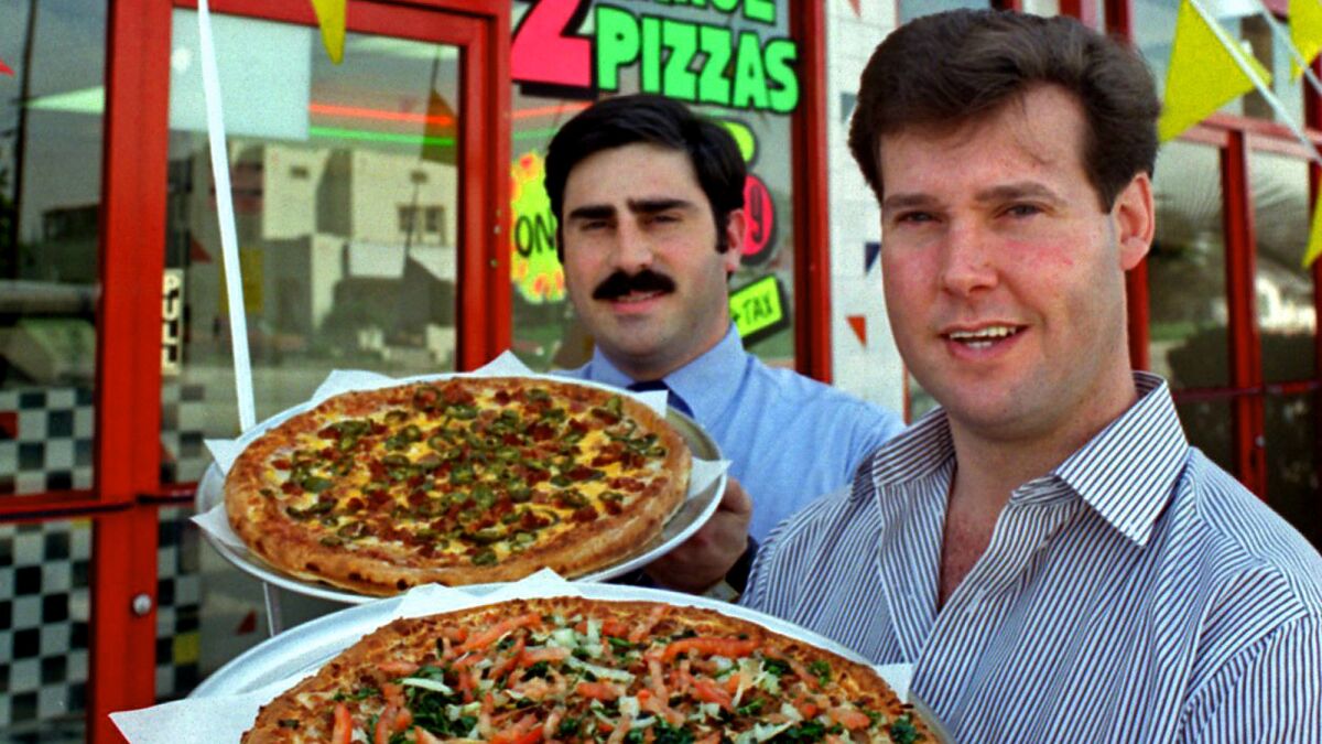 Alex Meruelo, right, and former La Pizza Loca executive Tony Tavantzis, in front of La Pizza Loca store in Buena Park in 1995.
