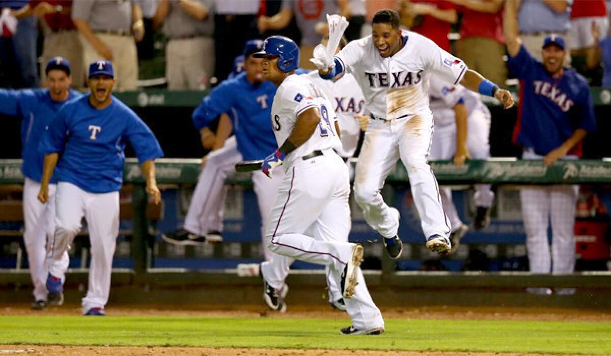 Adrian Beltre runs the bases while Elvis Andrus, right, celebrates his walk-off home run, the Texas Rangers' third consecutive victory over the Angels by home run.