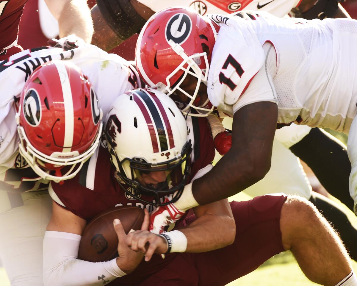 South Carolina quarterback Perry Orth (10) is sacked by Georgia defensive lineman Tyler Clark (52) and linebacker Davin Bellamy (17) on Oct. 9.