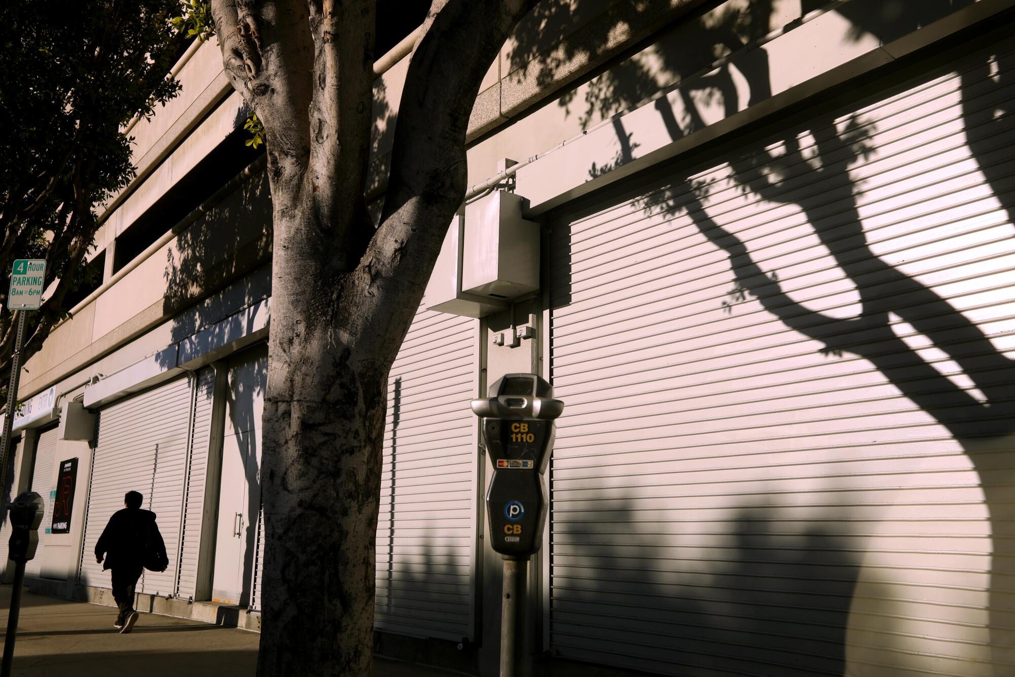 A pedestrian walks past closed shops.