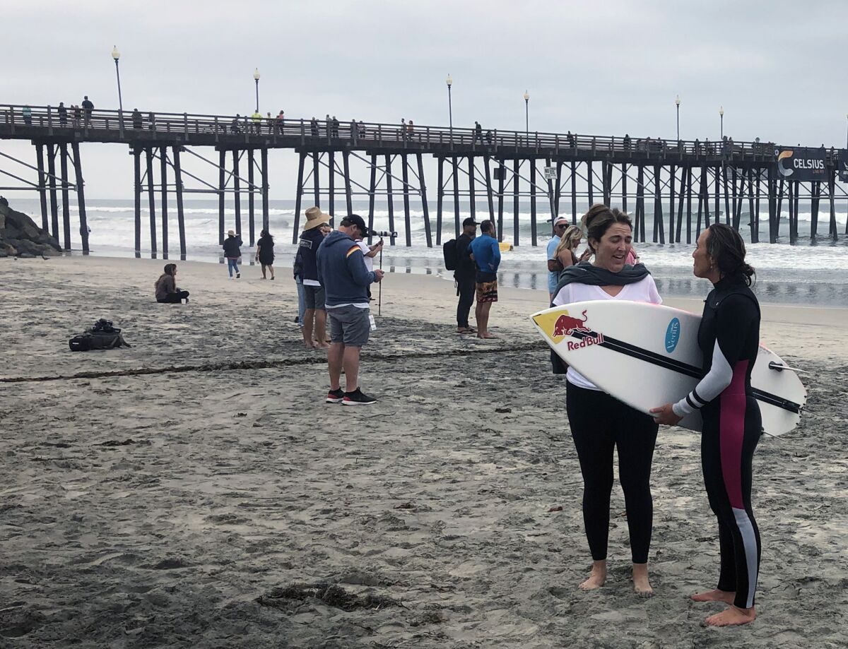 Carissa Moore, right, a five-time world champion surfer, talks to a fan on the beach near Oceanside Pier.