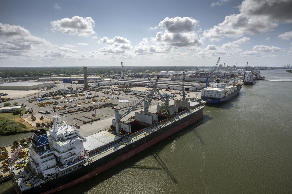 In this photo provided by the Georgia Ports Authority, three vessels work to load and unload cargo at the Georgia Ports Authority Ocean Terminal, June 24, 2022 in Savannah, Ga. On Monday, Dec. 5, 2022 the Georgia Ports Authority announced it will start remodeling the docks at Ocean Terminal in January 2023 to handle two large container ships simultaneously. The work will begin to transition the 200-acre facility to a container-only operation. (Stephen B. Morton/Georgia Port Authority via AP)
