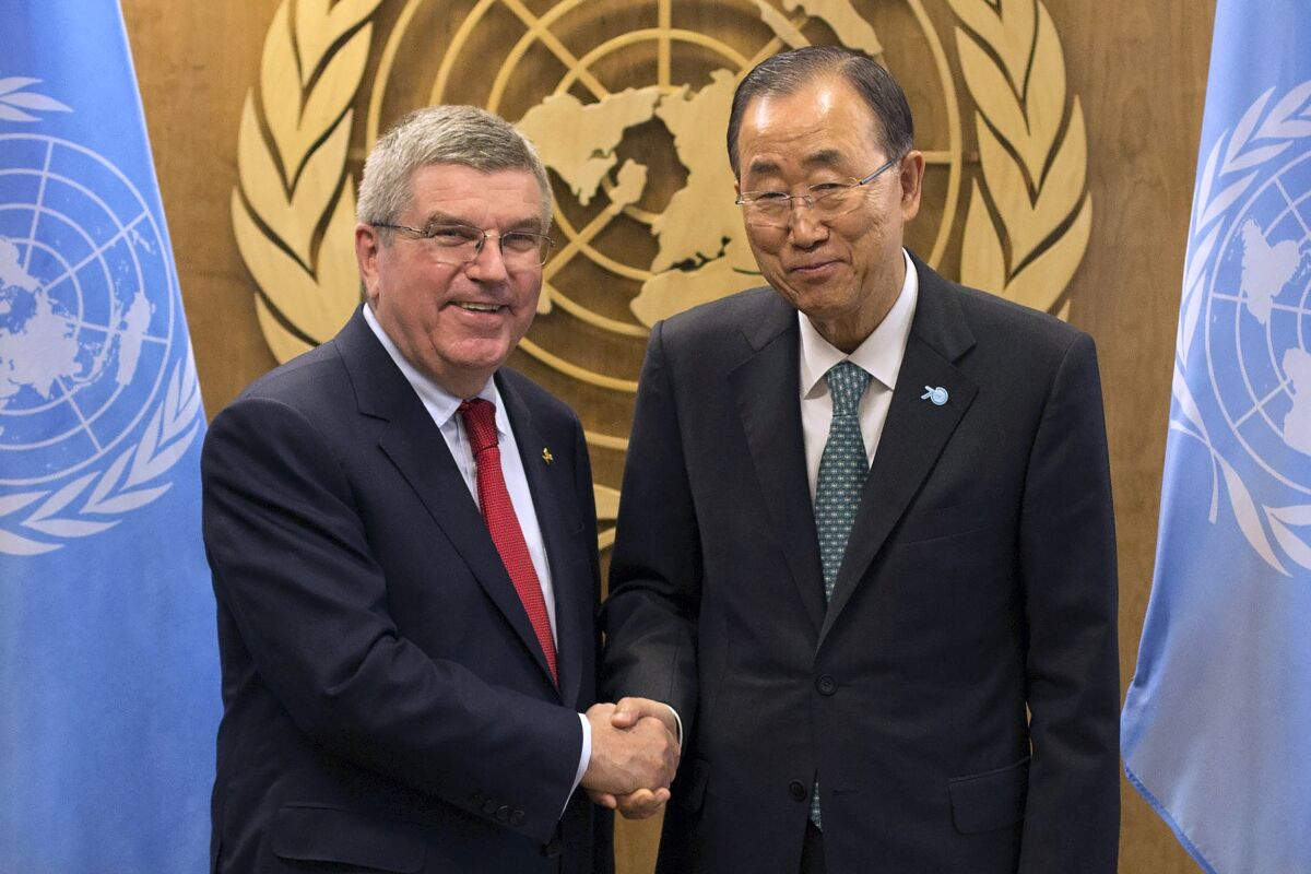 FILE - International Olympic Committee President Thomas Bach, left, shakes hands with United Nations Secretary-General Ban Ki-moon during a meeting at the United Nations headquarters Sunday, Sept. 27, 2015. The International Olympic Committee has always been political, from the sheikhs and royals in its membership to a seat at the United Nations to pushing for peace talks between the Koreas. But Russia’s invasion of Ukraine three weeks ago exposed its irreconcilable claims of “political neutrality.” (AP Photo/Kevin Hagen, File)