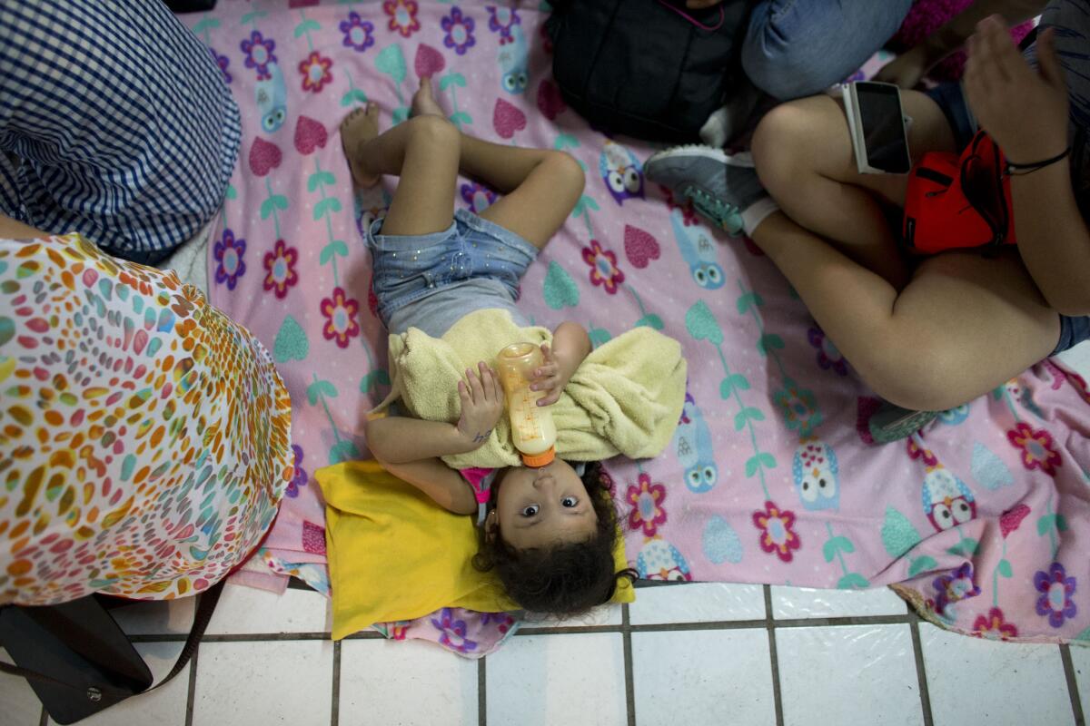 Una niña permanece sobre el piso de un albergue junto a su familia a la espera del huracán Patricia en Puerto Vallarta, Mexico, el viernes 23 de octubre de 2015. e. (AP Photo/Rebecca Blackwell)