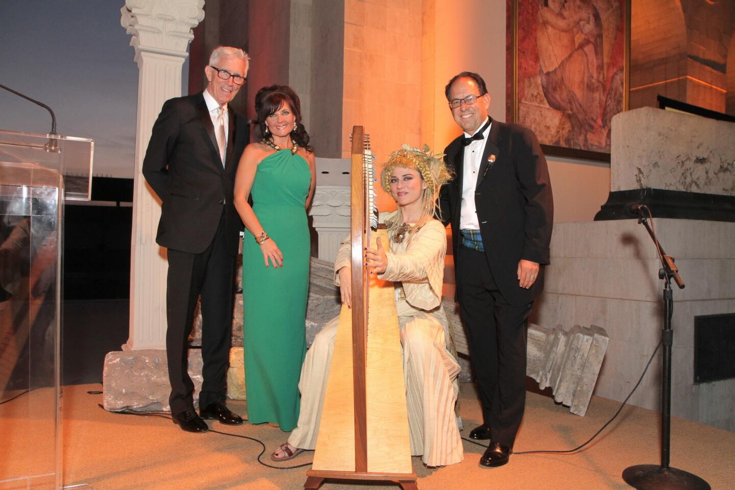 Weatherman Fritz Coleman, left, and Liz and Hal Snyder pose with harpist Regan Remy.