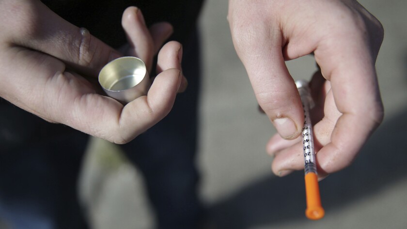 A fentanyl user holds a needle.