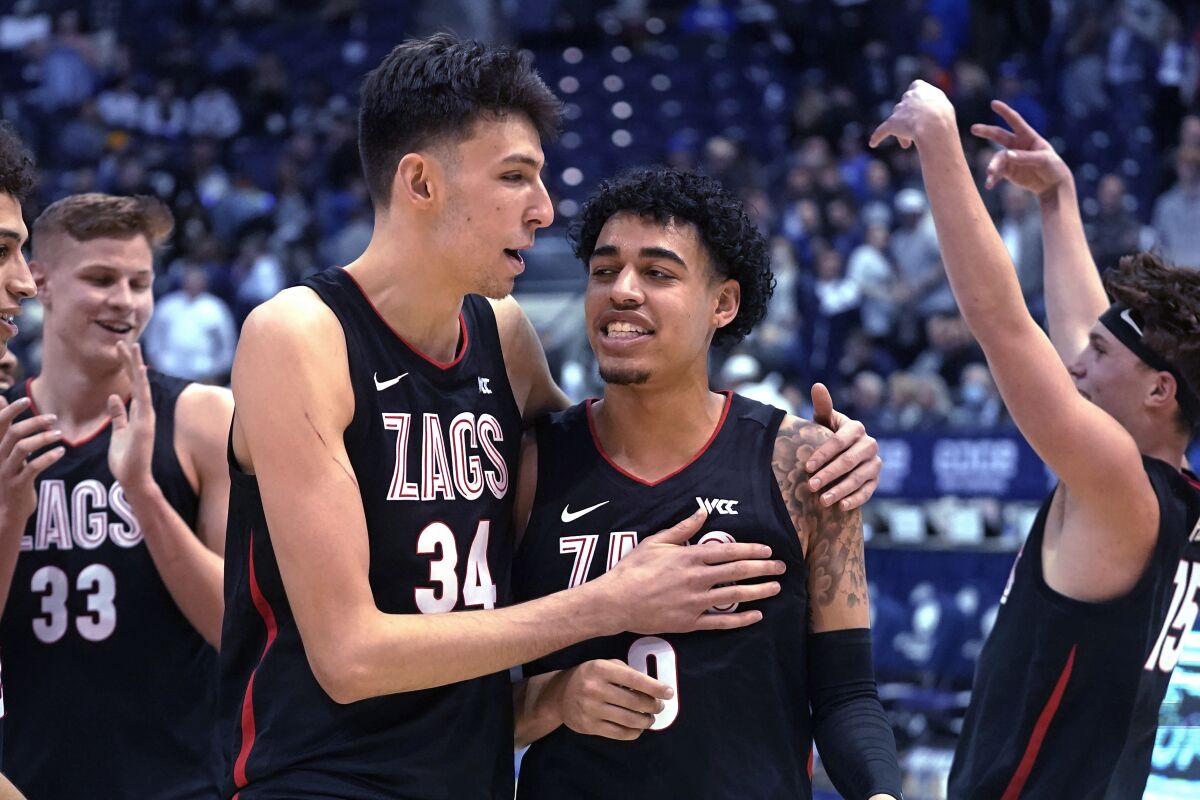Gonzaga center Chet Holmgren (34) andguard Julian Strawther (0) walk off the court following the team's win in an NCAA college basketball game against BYU on Saturday, Feb. 5, 2022, in Provo, Utah. (AP Photo/Rick Bowmer)