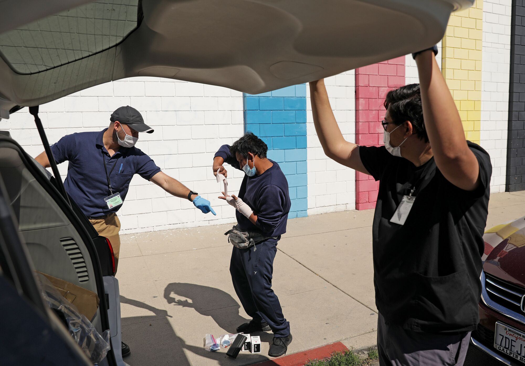 EMT Matthew Malloy and nurse Dionico Erazo tend to a man's injured hand in North Hollywood.