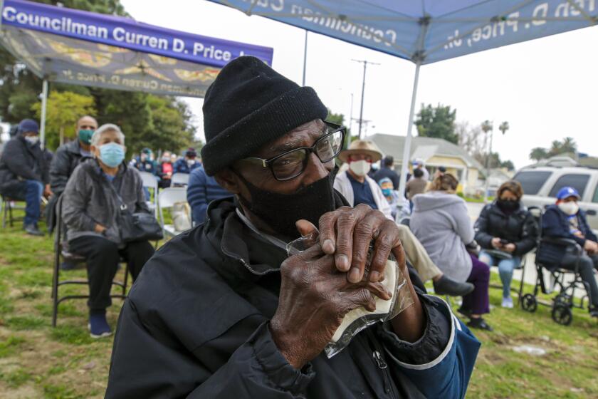 Los Angeles, CA - February 09: Anthony Angulo, 71, center, waits for his turn to get COVID-19 vaccine at a mobile vaccination site launched by Los Angeles Councilman Curren Price Jr. at South Park Recreation Center on Tuesday, Feb. 9, 2021 in Los Angeles, CA.(Irfan Khan / Los Angeles Times)