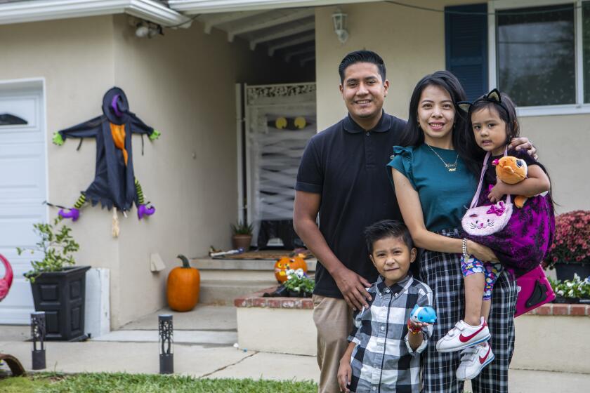 DUARTE, CA - OCTOBER 24: Portrait of Ruben Aguayo, Hazel Aguayo, Ariel Aguayo, 4, and Noah Aguayo, 5, in their yard Oct. 24, 2021 in Duarte, CA. Hazel and Ruben Aguayo recently purchased their house from Opendoor and their children particularly enjoy playing in both the front and back yard. Companies like Opendoor and Zillow are buying houses fast, with cash and mostly online and then reselling them after minor repairs. (Francine Orr / Los Angeles Times)
