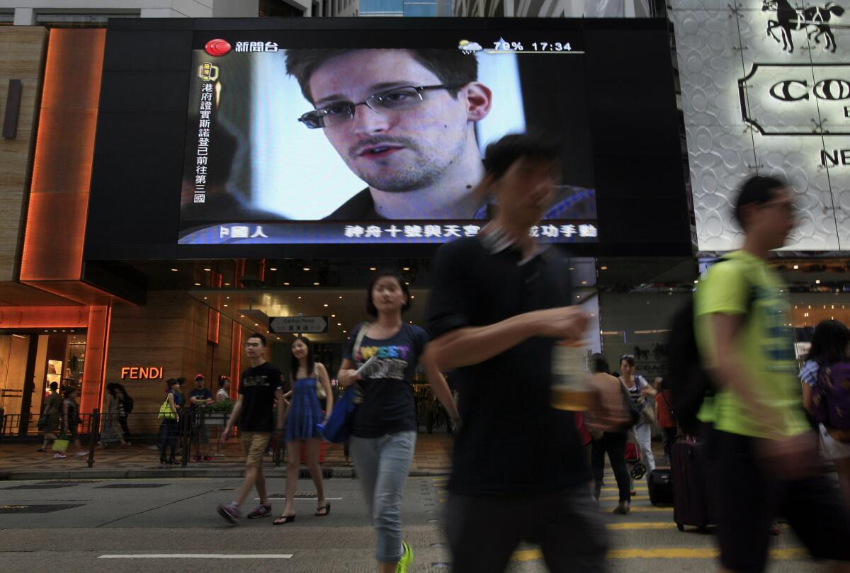 Edward Snowden, a former contractor for the NSA who leaked top-secret documents about sweeping U.S. surveillance programs, is seen on TV at a Hong Kong shopping mall last month. On Monday, Snowden issued a plaintive statement from his refuge at a transit area of Moscow's main international airport in which he accuses President Obama of making him stateless.