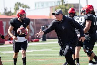 San Diego State offensive coordinator Jeff Hecklinski tosses a football to a player during practice on Wednesday, August 11, 2021.