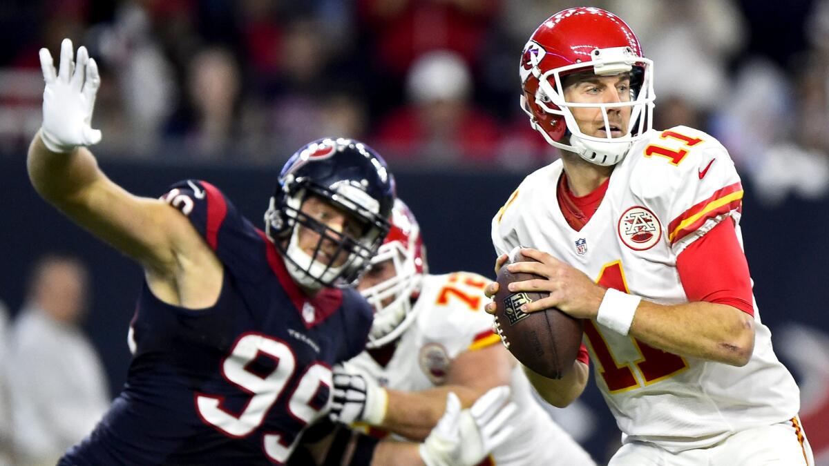 Chiefs quarterback Alex Smith (11) looks to pass as Texans defensive end J.J. Watt applies pressure during the second half Saturday.