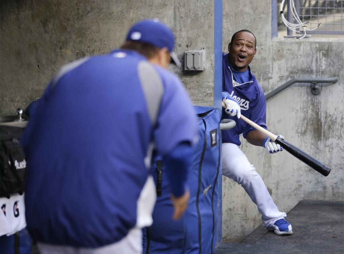 Juan Uribe jokingly bunts off of Hyun-Jin Ryu during practice at Dodger Stadium on Wednesday for Game 1 of the NLCS.