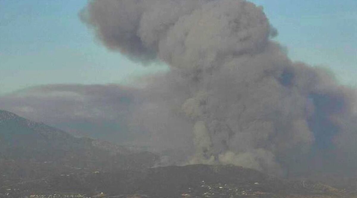 Black clouds of smoke emerge from the Apple fire near Cherry Valley in Riverside County. 