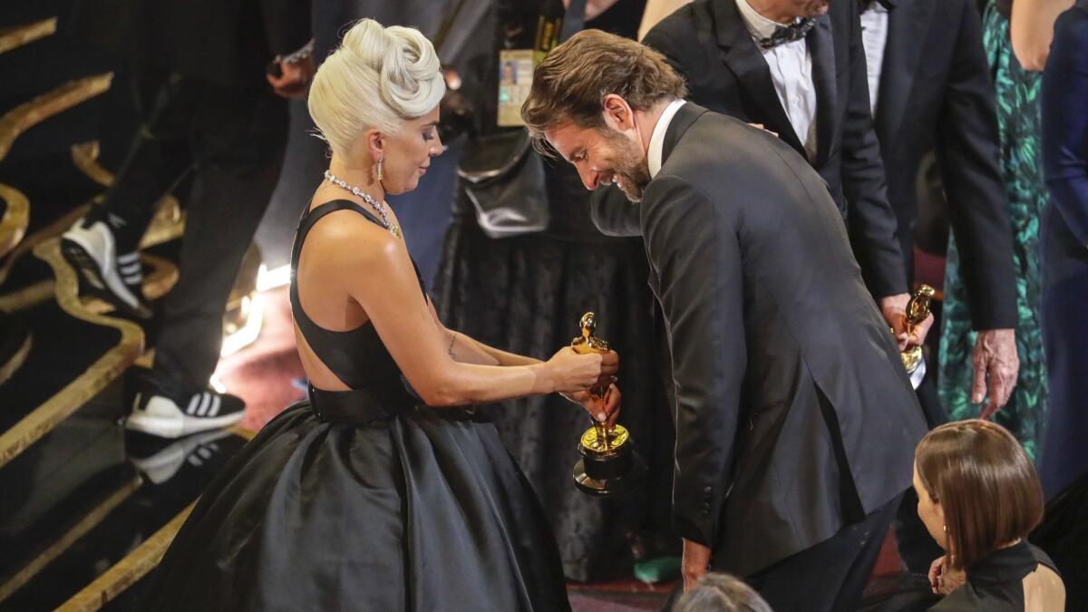 Gaga shows off her Oscar for original song to Cooper shortly after her win.