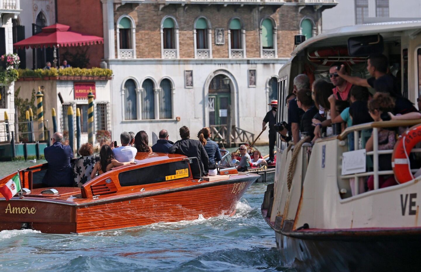 Lucky passengers on a tourist boat get a glimpse of George Clooney and company headed for their hotel.